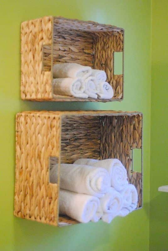 Small space hack Use every bit of space on the walls for extra storage baskets hanging on the wall holding guest towels