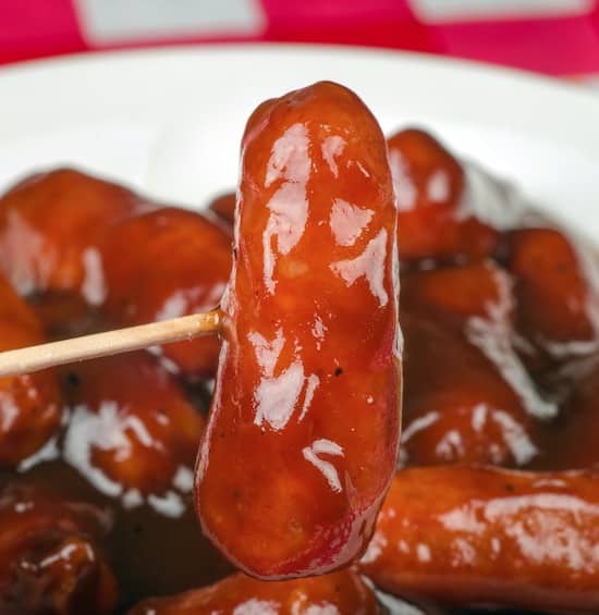 Cocktail sausage covered in bbq sauce and grape jelly on a toothpick for a party appetizer. 