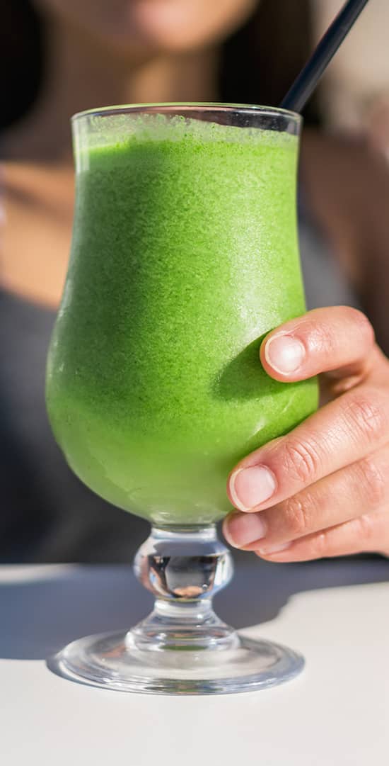 Healthy juicing lifestyle trend woman drinking green spinach juice