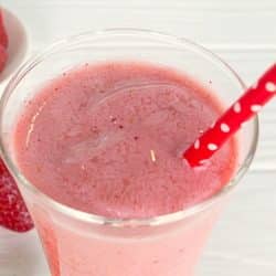 Strawberry Smoothie in a glass with red straw.