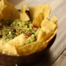 Bowl of avocado dip with chips ready for a party appetizer table