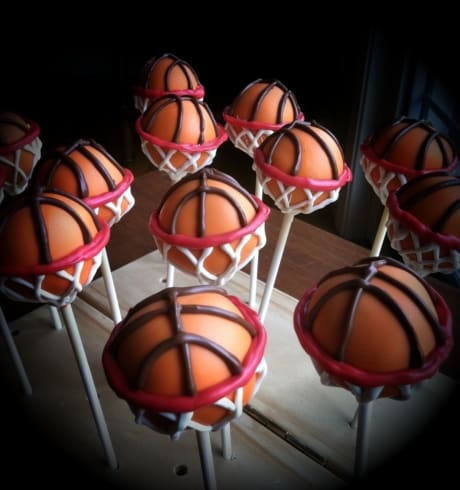 Creative DIY cake pops made to look like basketballs inside a basketball hoop perfect for a March Madness Party Favor.