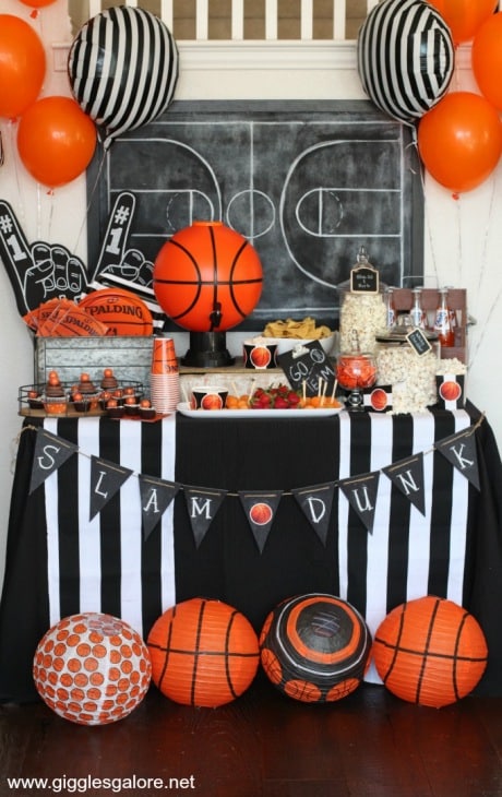 Basketball Theme decorations fill a table with basketball balloons at a March Madness Party for adults.