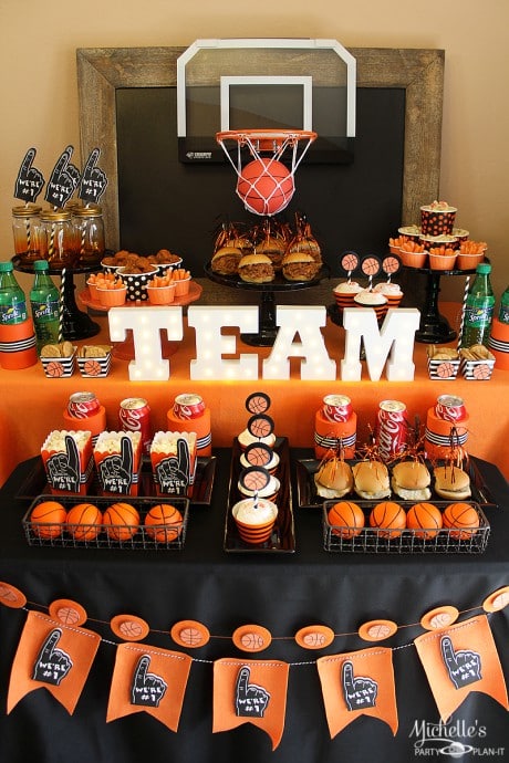 Party table decorations with Team centerpiece and basketball hoop for March Madness Basketball theme.