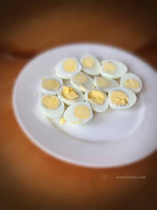 hard boiled eggs cut lengthwise showing yolks ready for step by step recipe instructions on making deviled eggs with paprika 