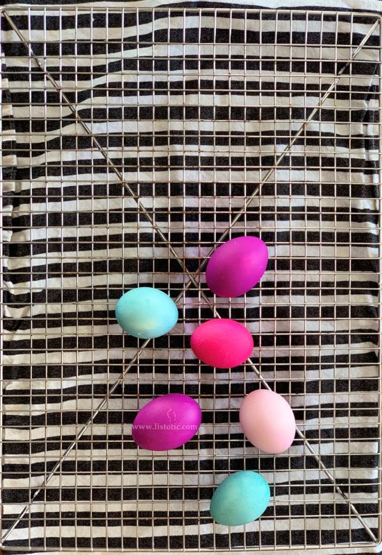 Six colorful Instant pot colored eggs on striped kitchen towel.