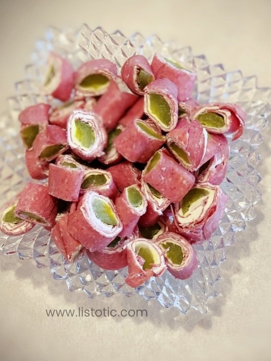 Decorative glass appetizer dish on a counter with completed sliced dill pickle roll up recipe, ready to be eaten. 