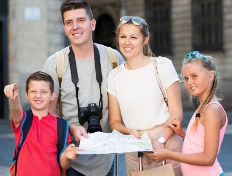 Family on a scavenger hunt, reading a map and looking for a landmark.