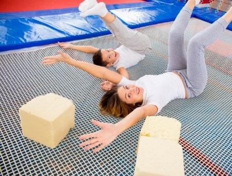 Mom and son jumping on trampoline at trampoline park.