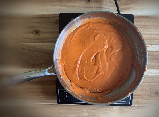 Hot skillet pan of melted candy corn, peanut butter and chocolate chips.