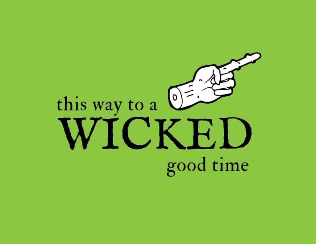 Green sign with a zombie and pointing out that says this way to a wicked good time.