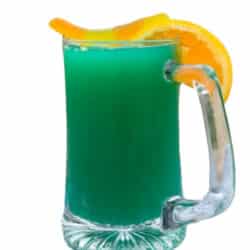 Mug of green beer garnished with an orange and gummy worm