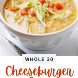 whole 30 cheeseburger soup in a bowl topped with shredded lettuce and diced tomatoes