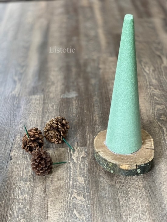 Floral Foam Cone on rustic wood slab and pine cones for Pine cone christmas tree craft