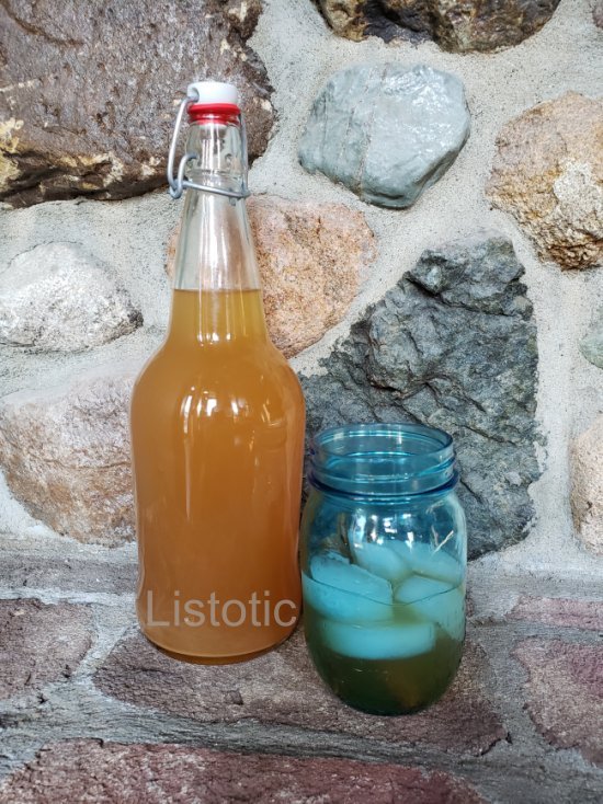 Bottle and glass with ice, cinnamon stick and Apple Pie Moonshine.