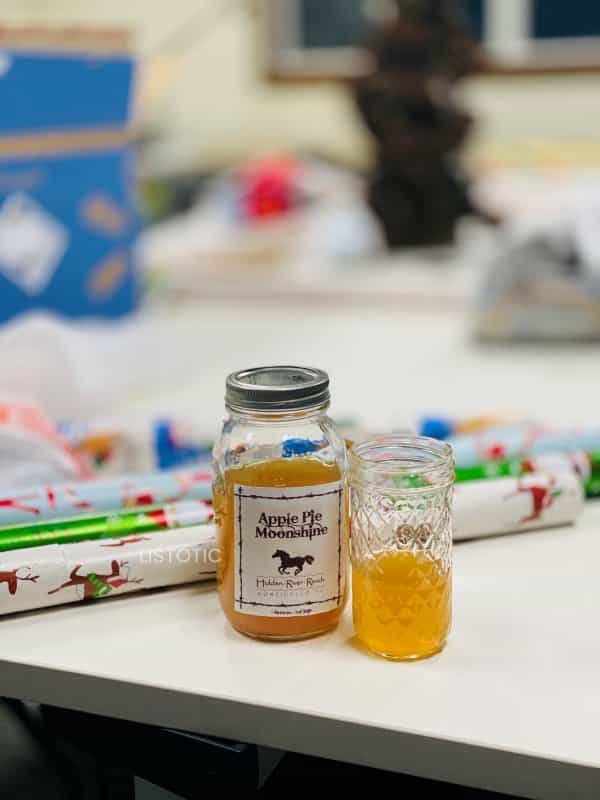 Apple Pie Moon Shine on a table being sipped on while gift wrapping for Christmas