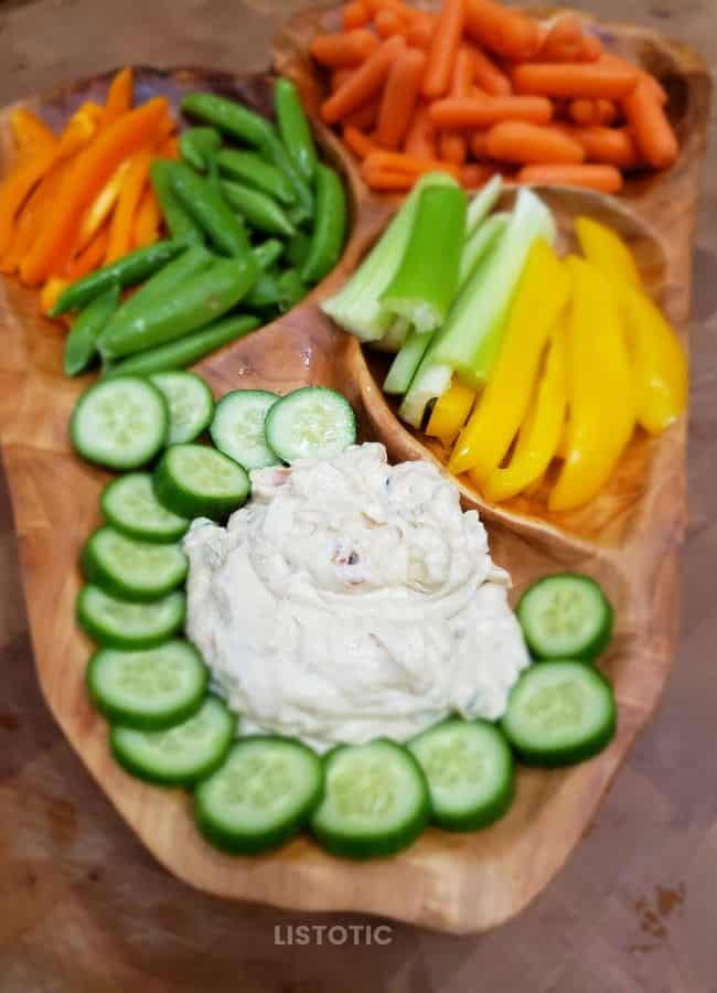 Veggies displayed on root wood platter with veggies.