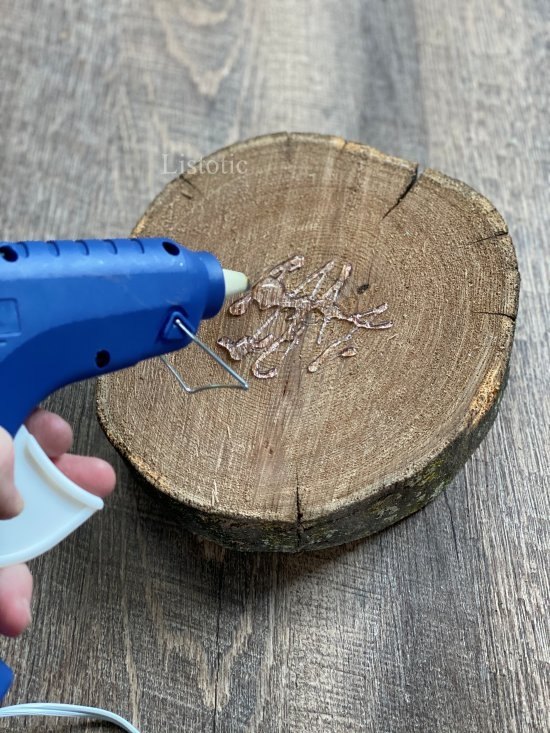 Wood slab with hot glue gun person applying hot glue