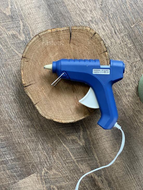 Glue gun resting on a wood slab