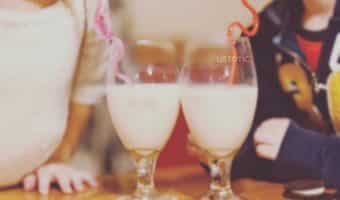 two kids enjoying strawberry milk with twisty valentines day straws