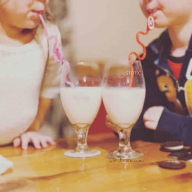 two kids enjoying strawberry milk with twisty valentines day straws 