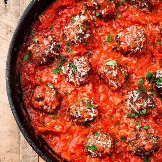 Gluten free savory keto meatballs and classic marinara in cast iron skillet.