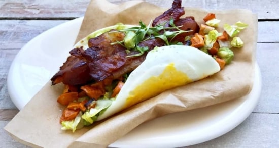 Lightly cooked pasteurized egg shell topped with bacon, lettuce, guacamole and diced sweet potatoes.