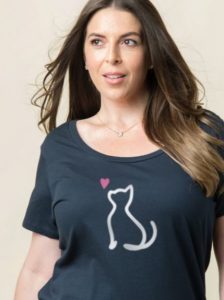 A woman wearing a navy colored t-shirt with a simple white line drawing of a cat with a pink heart beside it.