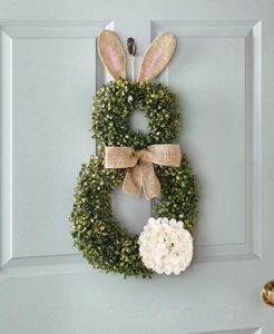 A bunny wreath hung on the face of a door.
