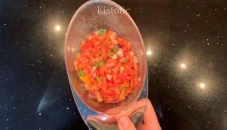 One cup of drained fresh salsa in a measuring cup.