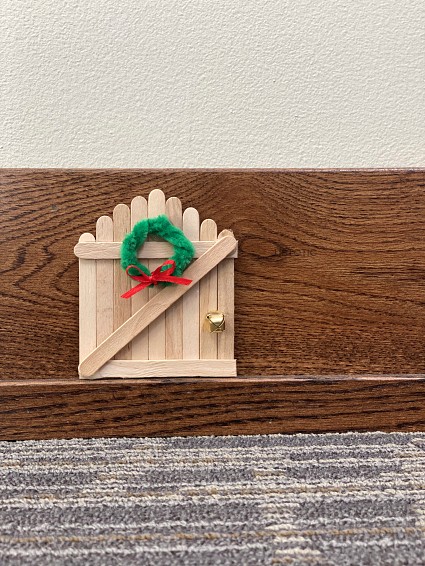 Elf on the shelf DIY elf door on the trim of a wall ready for elf foot prints to be added