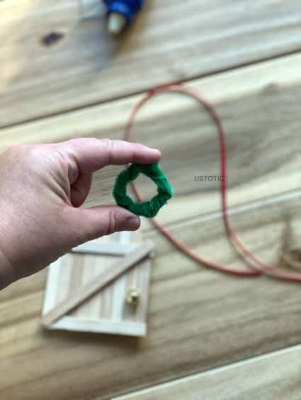 crafter using pipe cleaner to make a miniature wreath 