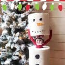 An Elf on the Shelf doll disguised as a toilet paper snowman.