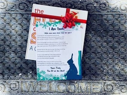 friendly arrival letter laying on the front door welcome rug with the Elf on the Shelf book