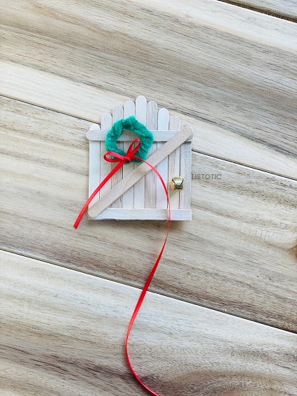 thin red ribbon tied in a bow around the diy miniature holiday wreath