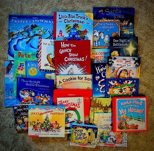 variety of Christmas books spread on the floor to be used for one of the elf on the shelf arrival ideas