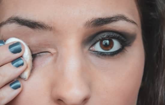 woman with cotton ball to remove face products