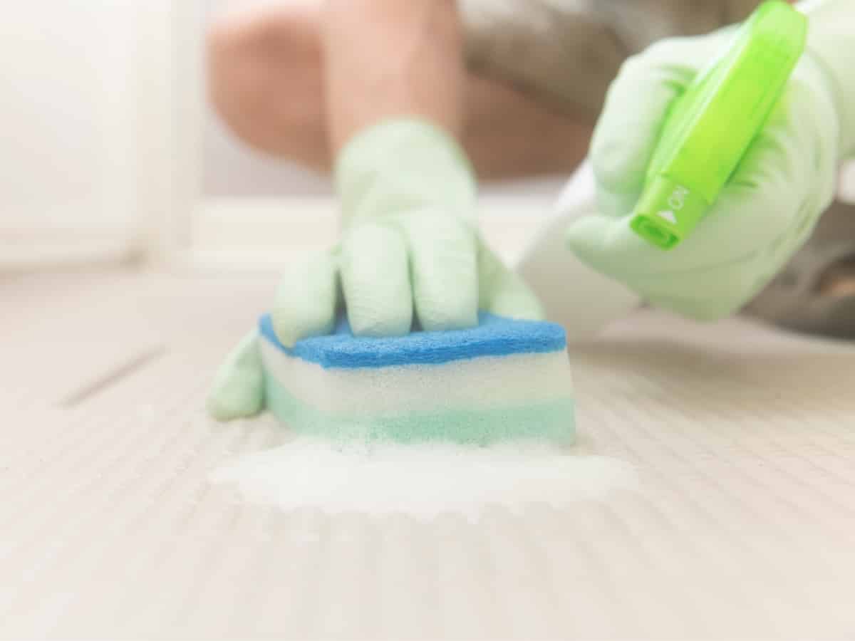 deep cleaning bathroom floor with sponge