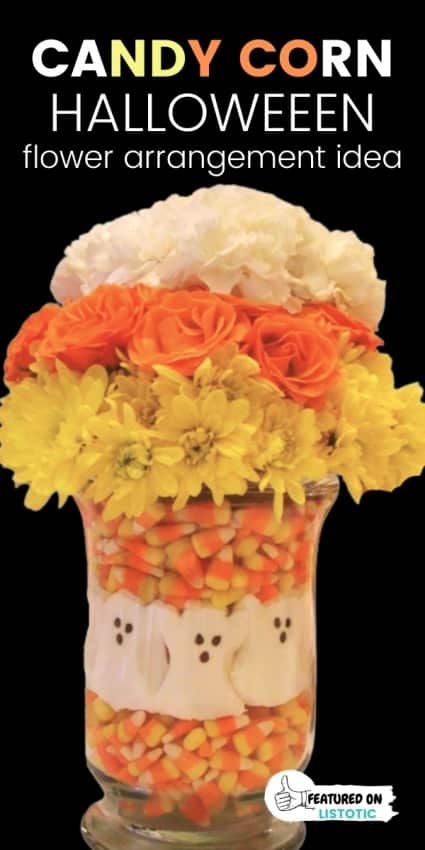 Halloween flower centerpiece with candy corn and white, yellow and orange flowers.