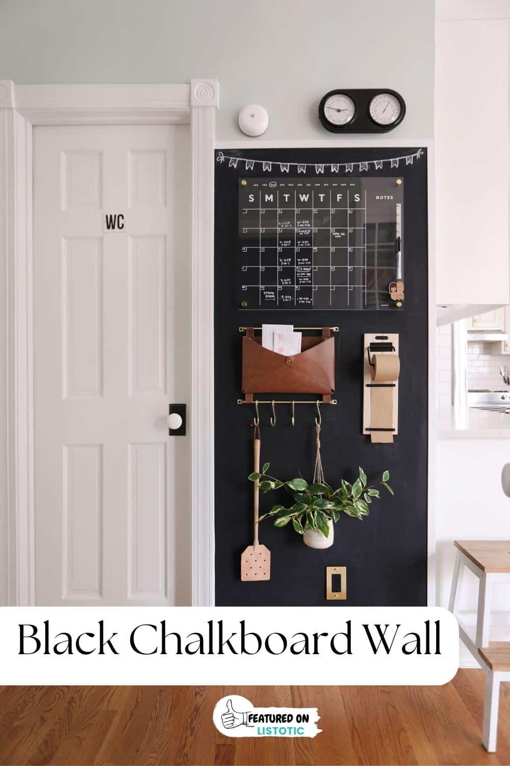 black chalkboard wall with calendar and catch all container on wall
