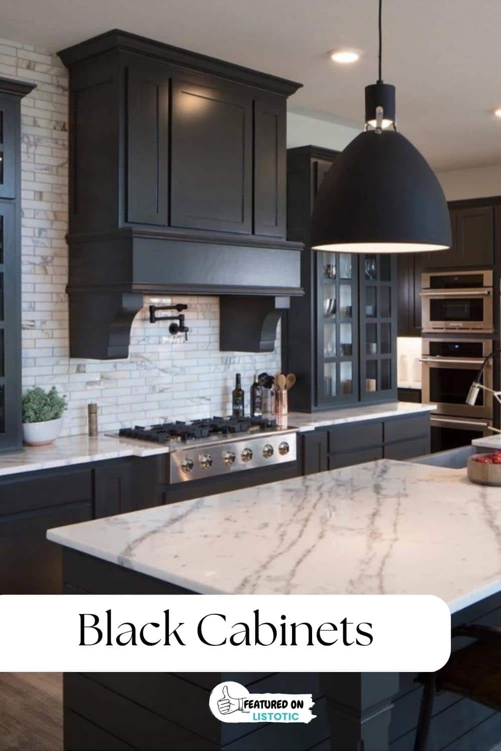 black kitchen cabinets with white vein counter and black wood range hood