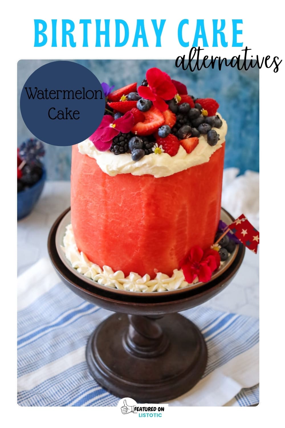 frosted watermelon cake with fresh berries on top on a cake stand